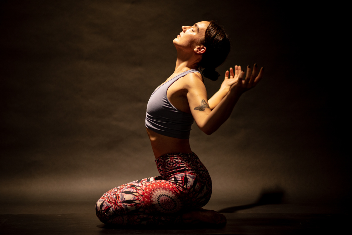 Young female yogi assumes open heart chakra posture
